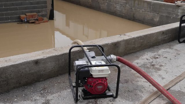 Footage of a flooded area and people pumping out water with a heavy duty high pressure aggregate pump machine from their houses and basements