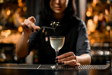 Close-up of bartender adding small branch in cocktail