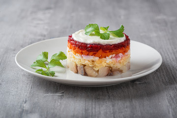 Traditional Russian salad herring under a fur coat, vintage wood background, selective focus