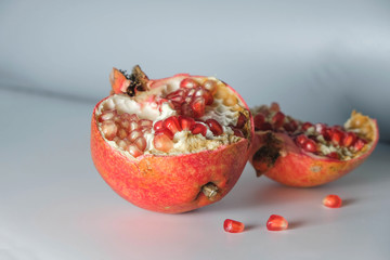 Sliced pomegranate isolated on a gray background in the morning light. Minimalism.