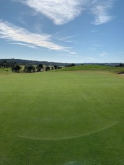 golf green with bunker and fairway in view