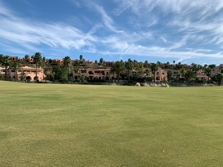 apartments next to golf course with blue sky above