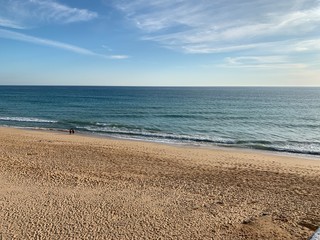 Fototapeta na wymiar beach and sea with blue sky and orange sand