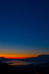 Bright blue sky and orange sunset and sea and bay far below. late evening at the resort by sea and mountains.