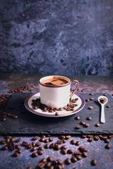 Roasted brown coffee beans and Turkish coffee on the rustic table. 