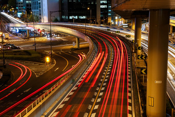 Fototapeta na wymiar Tokyo's night trail. Busy road and aerial highway beetween skyscraper.