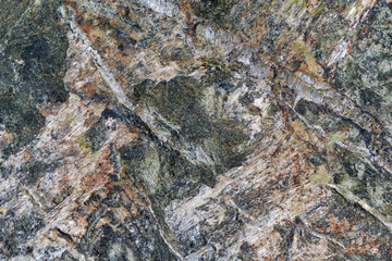 The surface and texture of the granite stone. Motley pattern of the surface with veins, spots, cracks. Background or backdrop.