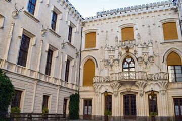 Deer heads on a stone wall with beautiful windows and balcony in an old castle