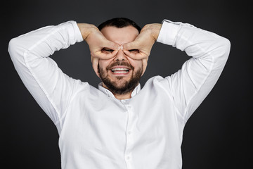 portrait of funny bearded man fooling around on black background.