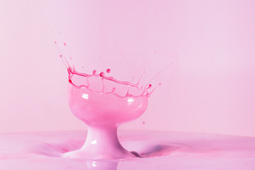 A macro photo of two drops of red food coloring colliding in a pool of thick creamy milk captured...