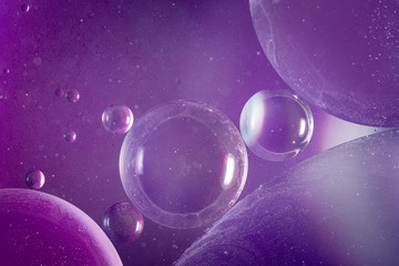 An abstract artistic close up macro photo created by mixing oil and water then back lit with a blue and purple flash