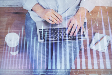 Multi exposure of market chart with man working on computer on background. Concept of financial analysis.