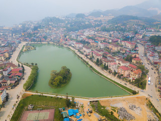 Obraz premium Aerial view of Sapa cityscape with Sapa lake an iconic emerald green lake in the downtown of Sapa the capital city in Lao Cai province in north-west of Vietnam.