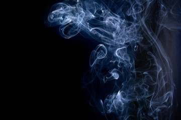 A close up macro photo of incense smoke lit by a blue flash to create a moody glow overlay with...