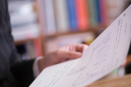 Businesswoman's Hand Holding Graph Report