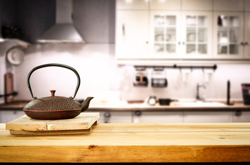 Kettle on wooden table and free space for your decoration.