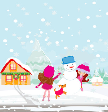 girls playing in a winter day, making a snowman