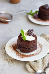 Warm dessert chocolate fondant with ice cream, mint and blackberry on the white plate. Lava cake recipe. Perfect dessert for Valentine’s Day.