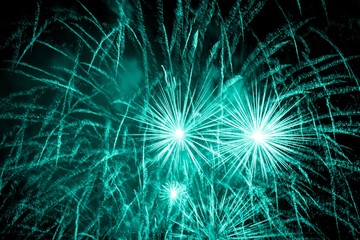 Luxury fireworks event sky show with turquoise big bang stars. Premium entertainment magic star firework at e.g. New Years Eve or Independence Day party celebration. Black dark night background