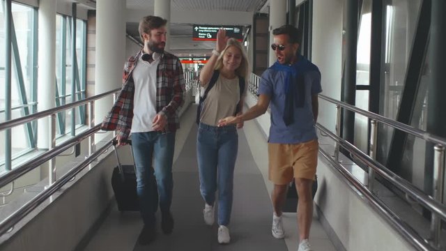 Cheerful friends go on a trip and walking to the airport