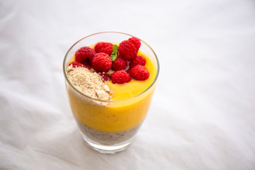 Chia pudding and Mango smoothie with raspberry and granola topping