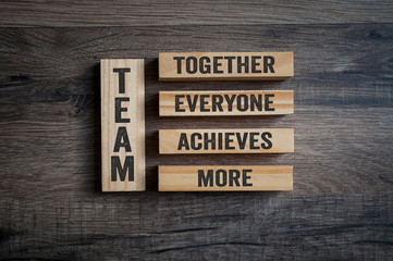 Wooden pieces with Team - Together everyone achieves more on wooden background