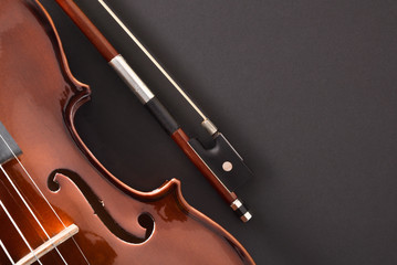 Violin body and bow detail on black table top view
