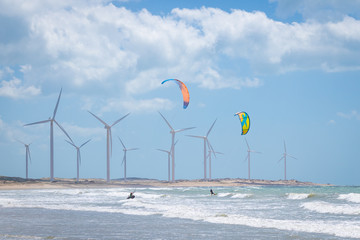 kite surfing in the sea with windmills in the background