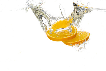 Fototapeta na wymiar whole orange and tangerine and sliced slices falls under water