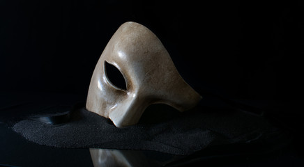 White opera mask on the sand - obrazy, fototapety, plakaty