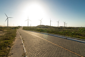 sunset on the road with wind farm in the background
