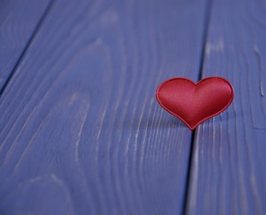 Fototapeta premium Valentine's Day, red satin heart on a wooden background.