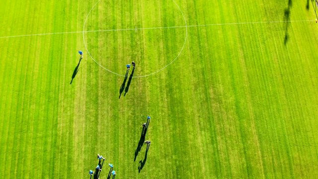 4K drone shooting while footballers are training on green stadium