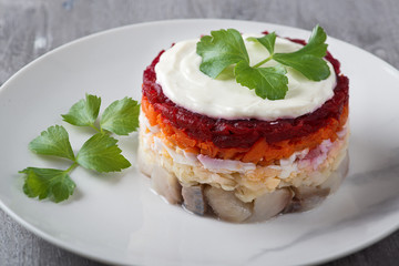 Traditional Russian salad herring under a fur coat, vintage wood background