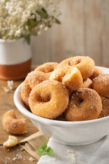 Typical spanish donuts, fried rosquillas with sugar for breakfast on rustic wooden table, traditional homemade anise donuts from Spain, typically eaten in Easter, copy space.