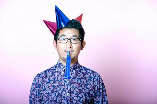 Young Geeky Asian Man Wearing Many Party Hats