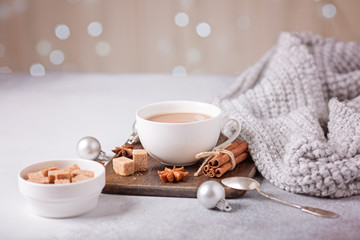 White cup with coffee and marshmallow, sweater, cinnamon. Cozy christmas composition. Hygge concept Soft focus