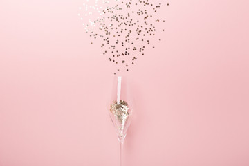 Christmas flat lay. Champagne glasses and gold decoration on pink background