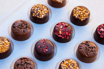 Delicious assortiment of chocolate candies with nuts, berries and caramel.