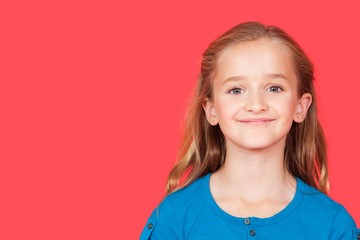 Portrait of young girl smiling against red background
