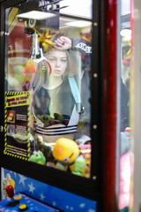 Beautiful girl behind the glass of the slot machine grab