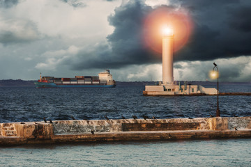 Dramatic seascape with lighthouse and ship