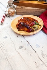 Chinese lacquered pork slices with its caramelized sauce prepared for eating in a wooden plate