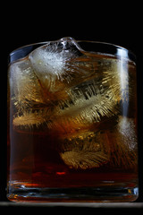 drink with textured ice cubes in a glass on a dark background