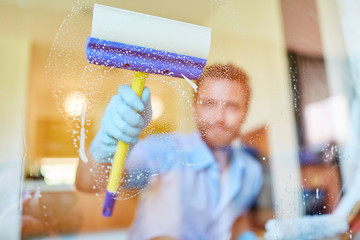 Hausmann oder Fensterputzer beim Fenster putzen