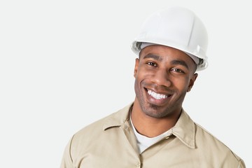 Portrait of happy African construction over with hardhat over gray background