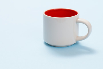 Empty porcelain coffee cup on blue background.