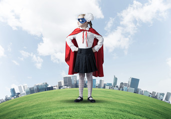 Girl power concept with cute kid guardian against cityscape background