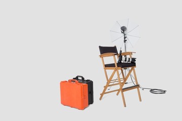 Director's chair and reflector umbrella with suitcases in studio