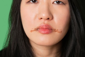 Portrait of a young woman with chocolate stains around her lips